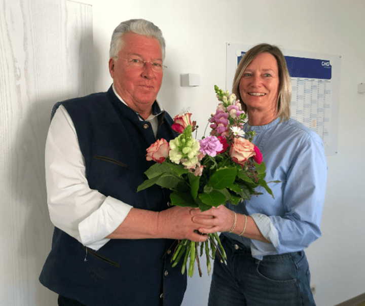 Abschiedsfoto von Frau Sohler und Herrn Dr. med. Locher, welcher Ihr einen Blumenstrauß überreicht